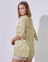 Blusa estampada con cuello redondo y abertura central con botones. Manga corta con lazo.