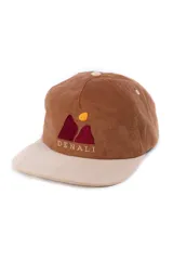 Gorra de pana color marrón con visera beige, con bordado de dos montañas rojas y un sol amarillo.