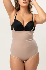 Faja abdominal color piel, de alta contención, cavada y reforzada en la zona abdominal. Tiene breteles desmontables y regulables, broche en la entrepierna con fundillo de algodón.