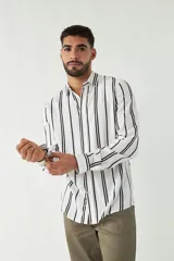Camisa de mangas largas con estampado a rayas verticales en tonos verde oliva, blanco y azul. Corte regular y logo bordado en el pecho. Confeccionada en viscosa.