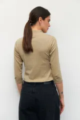 Polera de algodón color blanco, con cuello alto y mangas tres cuartos. Presenta un diseño ajustado al cuerpo con costuras decorativas en las sisas.