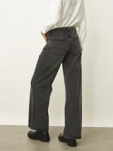 Jean de corte recto y tiro medio, confeccionado en denim de color azul clásico con costuras en contraste. Presenta diseño de cinco bolsillos y cierre frontal con botón y cremallera.