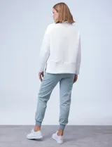 Buzo de jersey color lila con cuello alto y tajos laterales.