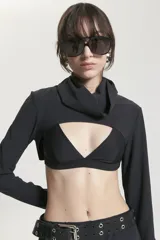 Top negro de microfibra con elastano, de mangas largas rectas y cuello alto amplio. Presenta abertura en el delantero y corpiño incorporado.