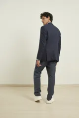 Saco azul de lino con dos botones, solapa de muesca, dos bolsillos delanteros con solapa y un bolsillo en el pecho.