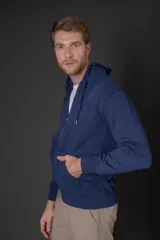 Campera con capucha y cierre frontal, confeccionada en algodón de color azul. Presenta bolsillos tipo canguro, puños y ruedo acanalados.