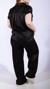 Pantalón blanco de satén con rayas verticales en relieve, corte palazzo y cintura elastizada con cordón ajustable.