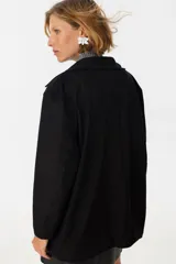 Tapado negro con cuello solapa, de corte recto y largo hasta la rodilla.