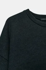 Top de tejido soft con cuello redondo, manga larga y bajo recto.