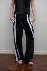Pantalón de terciopelo negro con bandas laterales blancas, cintura elástica y botamanga recta.