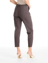 Pantalón de corte crop, color gris, con diseño de cinco bolsillos, cierre frontal con botón y ruedo irregular con terminación desflecada.