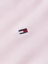 Remera Tommy Hilfiger de color rosa claro, confeccionada en algodón puro, con cuello en V y logo bordado en el pecho.