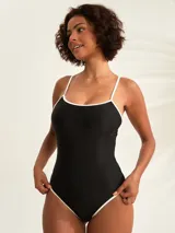 Malla entera negra con finos breteles y ribetes blancos en contraste a lo largo del escote y las piernas.
