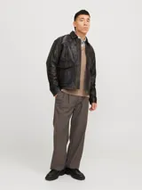 Campera de cuero marrón con cuello biker y cierre con cremallera. Confeccionada en cuero de cabra suave, naturalmente resistente al agua. Presenta mangas largas y bolsillos frontales con cierre de botón.