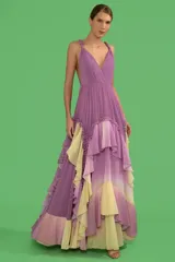 Vestido largo lila con degradé amarillo, de tirantes finos retorcidos, busto plisado, escote cruzado, espalda descubierta y falda con volados.