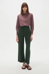 Pantalon tipo jean de corte flare y tiro alto, color verde oscuro, con cierre frontal y bolsillos.
