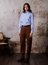 Pantalón cargo marrón de corte recto, con bolsillos laterales y cinturón de cuero marrón.