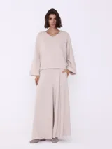 Pantalón palazzo color visón, de corte ancho y tiro alto.