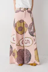 Pantalon de corte wide leg y tiro alto, color rosado con estampado de motivos deportivos como pelotas de fútbol y raquetas de tenis. Cuenta con cierre frontal con botón y bolsillos laterales.