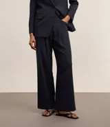 Pantalón de vestir azul marino, de corte wide leg, con cintura alta, pliegues frontales, bolsillos laterales y aplicación de strass.