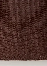 Chaleco de punto grueso color marrón, con diseño recto, cuello redondo y manga larga.