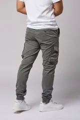 Pantalón cargo color beige de gabardina, con corte ajustado, bolsillos laterales con fuelle y puños elásticos en los tobillos.