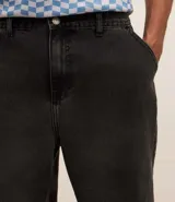 Pantalón de jean corte baggy, de tiro alto y pierna ancha, con diseño de cinco bolsillos, trabillas para cinturón y cierre frontal con botón y cremallera.