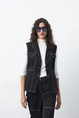 Chaleco de estilo utilitario color bordó con pespuntes blancos a contratono. Presenta solapas, cierre frontal con botones, bolsillos delanteros y un diseño estructurado.