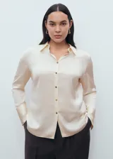 Camisa de corte clásico con acabado satinado, cuello camisero, cierre frontal con botones y manga larga con puños abotonados.