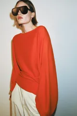 Jersey de punto con cuello barco y mangas anchas tipo murciélago, de diseño holgado y fluido.