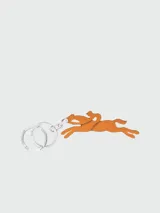 Llavero Longchamp con dije de cuero color tostado con forma de jinete sobre un caballo al galope y argolla metálica plateada grabada con el nombre de la marca.