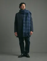 Gabardina clásica de corte recto y largo medio, color azul marino. Cuenta con cuello camisero, cierre frontal con botones, bolsillos laterales y ajuste en los puños.