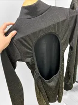 Vestido corto negro con lurex dorado, de cuello alto y mangas largas.