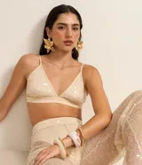Top cropped de poliéster color beige con lentejuelas, escote en V y tirantes finos ajustables.