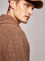 Cárdigan de punto jaspeado color gris oscuro, con cuello smoking, cierre frontal con botones de madera y ochos en el tejido.