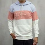 Canguro de algodón con capucha, diseño a bloques de color celeste, salmón y blanco, con logo bordado en el pecho.