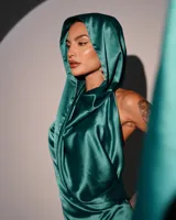 Minivestido satinado color verde esmeralda, con capucha, espalda descubierta y drapeado en la falda.