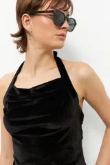 Top negro de terciopelo con escote halter, sin mangas y espalda descubierta.