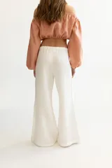 Pantalón color beige de lino, con elástico y tira ajustable en la cintura, bolsillos a ambos lados y pata de elefante estilo Oxford.