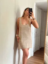 Vestido corto de tejido de punto, color marrón con hilos dorados (lurex) que le dan un brillo sutil. Diseño de tirantes anchos y escote redondo.