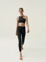 Top deportivo color beige con diseño asimétrico y tirante ancho en un hombro.