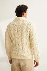 Sweater de lana color beige, tejido a mano con ochos y cuello cruzado. Terminaciones en punto elástico en puños y ruedos.