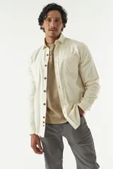 Camisa rústica lisa de manga larga color verde militar, con cuello clásico y dos bolsillos frontales con solapa.