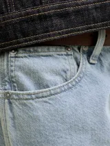 Shorts de denim de corte holgado y largo hasta las rodillas, en color celeste claro, estilo bermuda de jean.