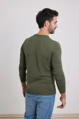 Sweater de punto liso, color azul, con escote redondo y manga larga.