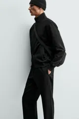 Sudadera de algodón color negro, de corte regular fit, con cuello alto, cierre frontal de cremallera bidireccional y bolsillos frontales de vivo.