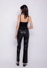 Pantalón oxford de cuero sintético negro, con cuatro bolsillos, cierre frontal con dos botones y presillas para cinturón.