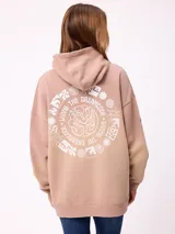 Canguro oversize color tostado con capucha y estampa circular blanca en la espalda que incluye gráficos variados y la frase 'Living the dreamcode'.