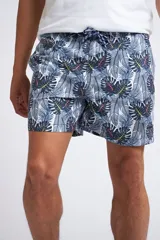 Short de baño con cintura elástica y cordón ajustable, confeccionado en tela ligera de secado rápido. Presenta un estampado botánico integral en tonos amarillos, blancos y azules, con dos bolsillos delanteros y uno posterior.