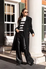 Sweater de punto con cuello alto y rayas horizontales negras sobre fondo blanco.